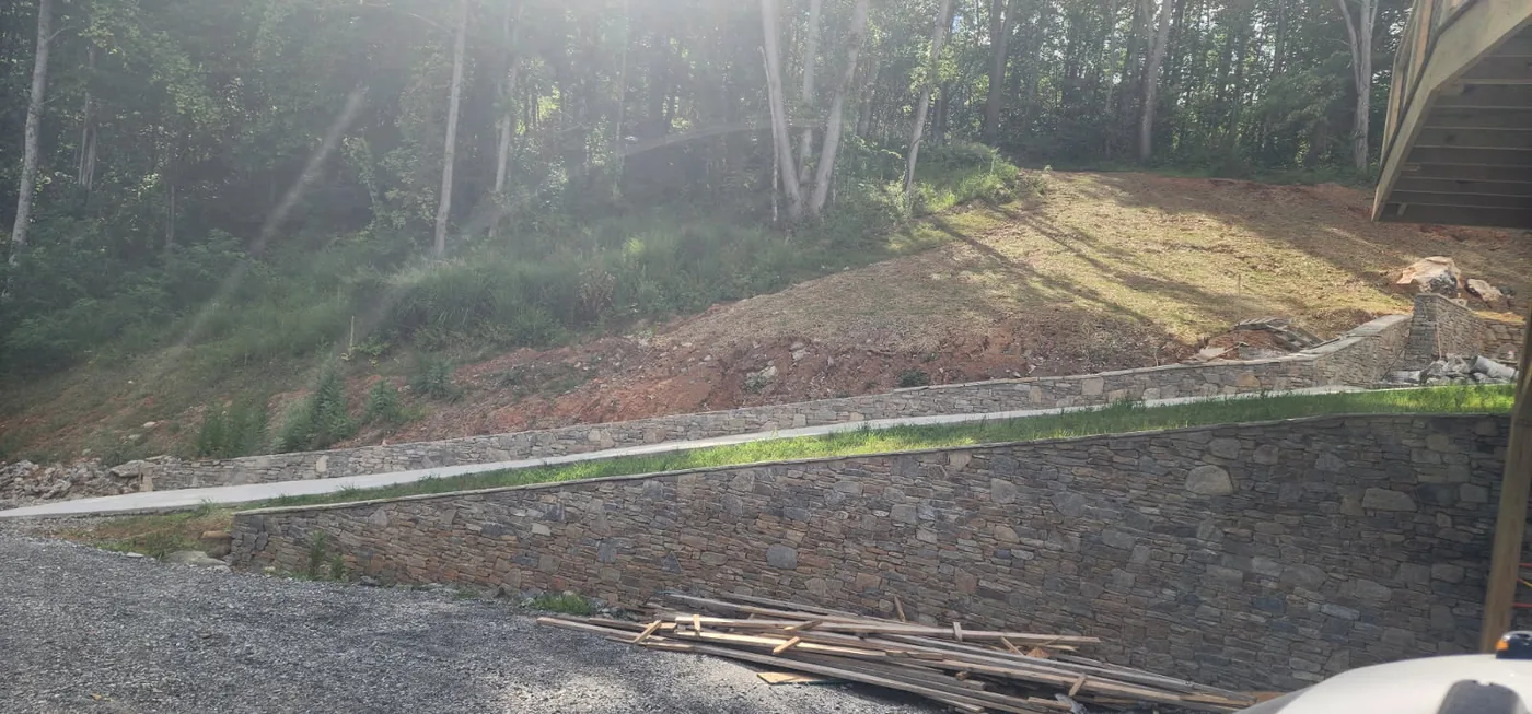 Mortared fieldstone retaining walls stepping up a mountain driveway